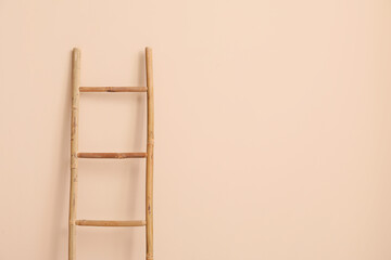 Wooden ladder near beige wall in room