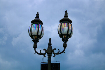Fototapeta na wymiar Vintage street lamp. Street light. Two street lamps on a pole against a cloudy sky.