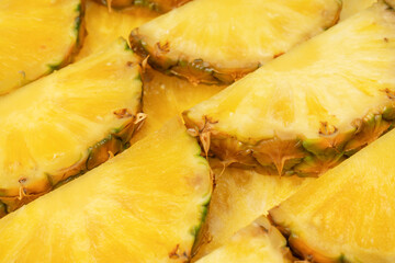 Pineapple juicy yellow slices as a background.