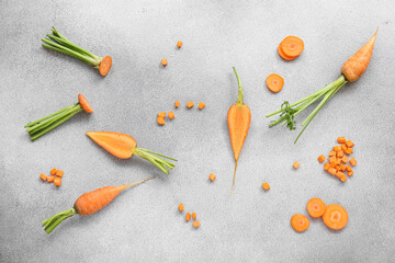 Fresh carrots and slices on grey background