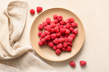 Plate with fresh raspberries on white background