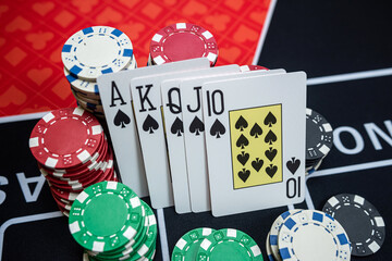 The winning combination  Royal flush with chips at casino table