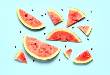 Pieces of fresh watermelon and seeds on blue background