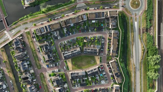 Real Estate, Top Down View of Modern Residential Houses in Amsterdam, Weesp, Netherlands. New Townhouses District With Solar Panels Built-in on Building's Roofs, Cars parked on Terraced Parking Lots.  