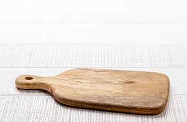 Wooden cutting board on white kitchen table