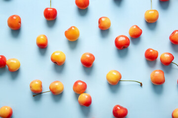 Many sweet yellow cherries on blue background