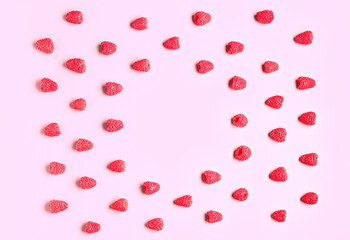 Frame made of fresh raspberries on pink background