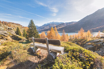 Panoramic wooden tourist bench on lakes in the Swiss Alps