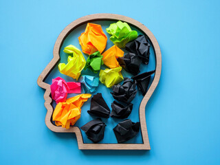 Negative and positive thoughts concept. Head shape with color and black paper balls.