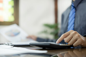 Fototapeta premium The business hand sits at their desks and calculates financial graphs showing the results of their investments planning the process of successful business growth