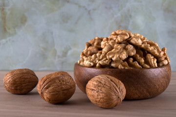A bowl of peeled walnuts and a group of shelled walnuts
