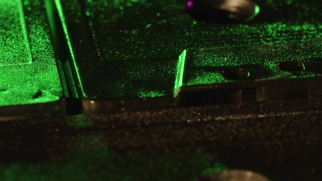 Macro shot of tape capstan hole notches spins with green, pink and purple.