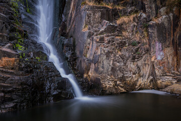 long exposure shot of waterfall surround with rock 