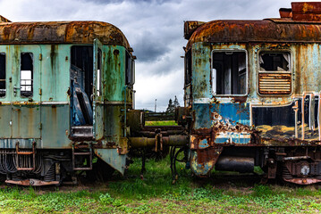Old rusty electric multiple units abandoned on unused railway tracks