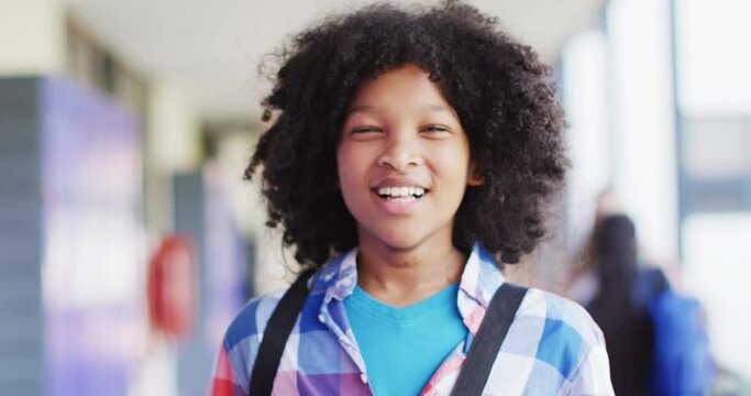 Portrait of happy diverse schoolchildren at locker in school