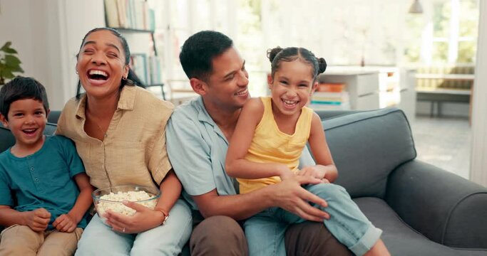 Happiness, parents and kids watching tv, laughing at comedy and quality time together in living room. Mom, dad and children with funny movies, bonding and happy family on sofa with television show.