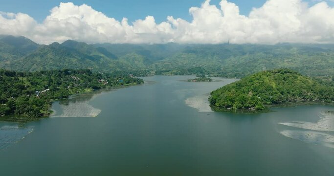 Mountain with rainforest sorrounded in Lake Sebu. Blue sky and clouds, drone view. Mindanao, Philippines.