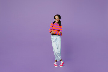 Fototapeta premium Full body smiling happy fun little kid teen girl 15-16 years old wear striped orange sweatshirt hold hands crossed folded look camera isolated on plain purple background. Childhood lifestyle concept.