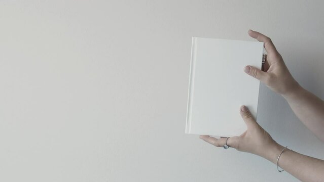 White books in female hand. Get new knowledge. Read book. Self-education. Concept. Improve yourself. On a white background.Student. School and university. Library. 
