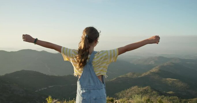 A magical moment of a Caucasian teenage girl raising her arms atop a mountain in the west of Swansea. Hiking in the Gorchy ridges, travel and tourism. High quality 4k footage