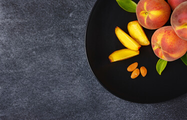 Harvest of peaches for food or juice. fresh organic fruit, vegan food. Large peaches on dark table background, selective focus.