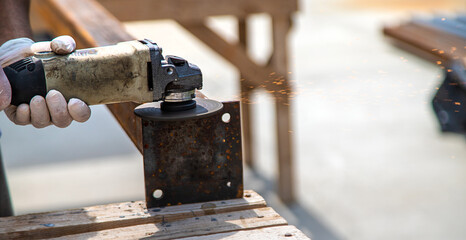 A man processes a metal pole. Selective focus.