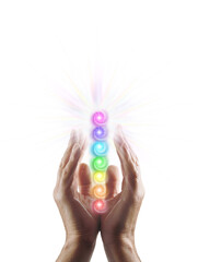 Male Reiki Healer hands palm sides facing inwards cupped around seven rainbow coloured chakra stack...