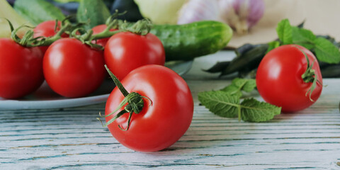 Tomatoes, cucumbers and mint leaves on a wooden table, organic natural vegetables
