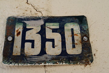 Numéro 1350. Numéro de rue. Plaque émaillée rouillée blanche et bleue.
