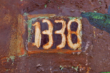 Numéro 1338. Numéro de rue sur porte rouillée.