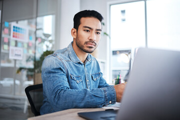 Thinking, laptop and man at desk reading email, feedback or research planning at design agency job. Business, website and computer, employee in office checking online report at tech startup workshop.