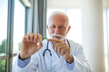 Doctor online. Senior medic talking to client on laptop computer from his office. Mature male therapist explaining medical treatment to patient through a video call with laptop in the consultation.