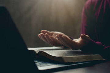 Hands together in prayer for god blessing to wish to have a better life. man hands praying to god with the bible on his laptop. believe in goodness. spirituality and religion, and bible prayer online - obrazy, fototapety, plakaty