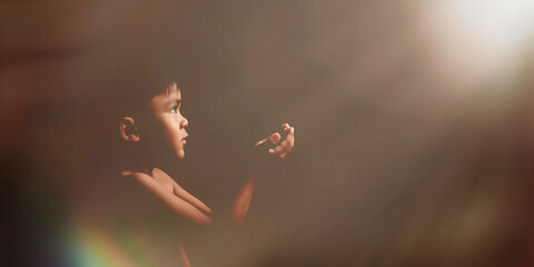 Portrait of praying boy on dark background