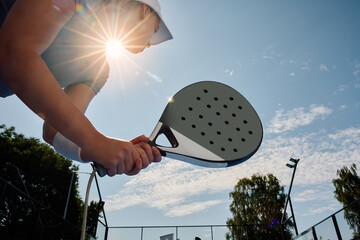Below view of female paddle tennis player during match. - obrazy, fototapety, plakaty