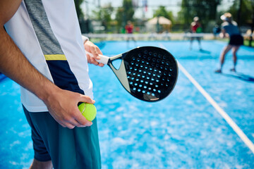 Close up of man serving during padel tennis match.