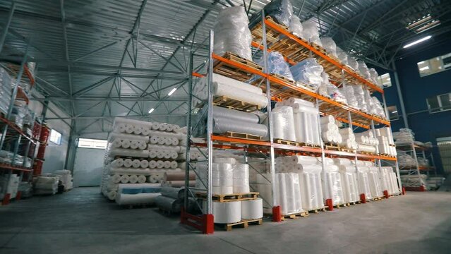 Warehouse with rolls of nonwovens. Large warehouse in a nonwoven fabric factory. Large roll of spunbond