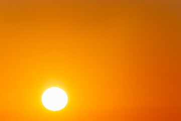 rising sun against clear orange sky