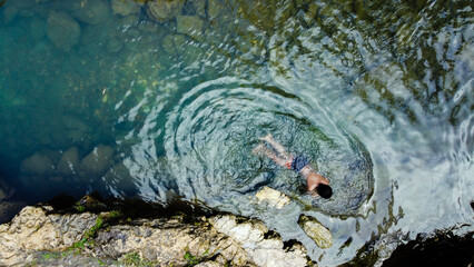 Top view of little boy swimming in river