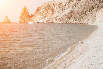 Remote beach, calm sea with volcanic rocky shores, with small waves on the water surface. The summer ocean beach, a holiday, vacation, and travel concept with a focus on natural scenery. Nobody