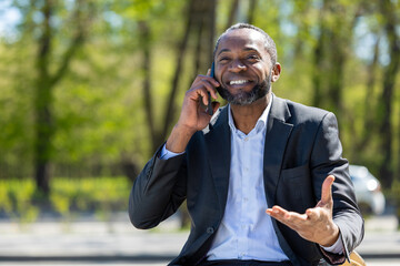 African american businessman talking on the phone and looking excited