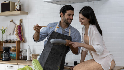 Romantic young couple is cooking in kitchen at home