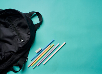 Backpack with stationery on blue background
