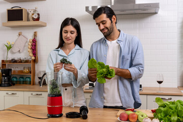 Happy young couple Cooking Healthy Vegetable mixer in Kitchen