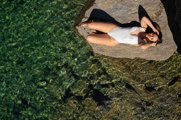 Woman Sunbathing in a Swimsuit at Caumasee, Flims, Switzerland in Summer