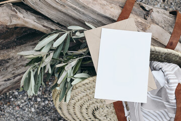 Summer lifestyle composition. Blank greeting card invitation mockup. French basket, straw bag with...