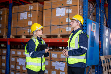 Industry warehouse worker in safety uniform check order details and checking goods supplies on boxes shelve in workplace warehouse industry logistic export import distribution business concept.