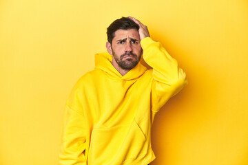 Obraz premium Man in yellow hoodie, monochrome studio backdrop being shocked, she has remembered important meeting.