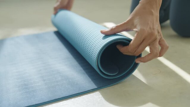 Hand of asian woman mat yoga apart rolling up and preparing to doing yoga class 