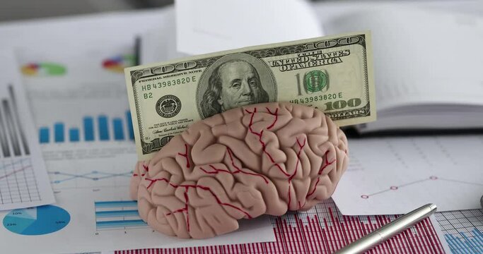 Mock-up of artificial human brain and hundred dollar bill on table. Investment investment in education concept